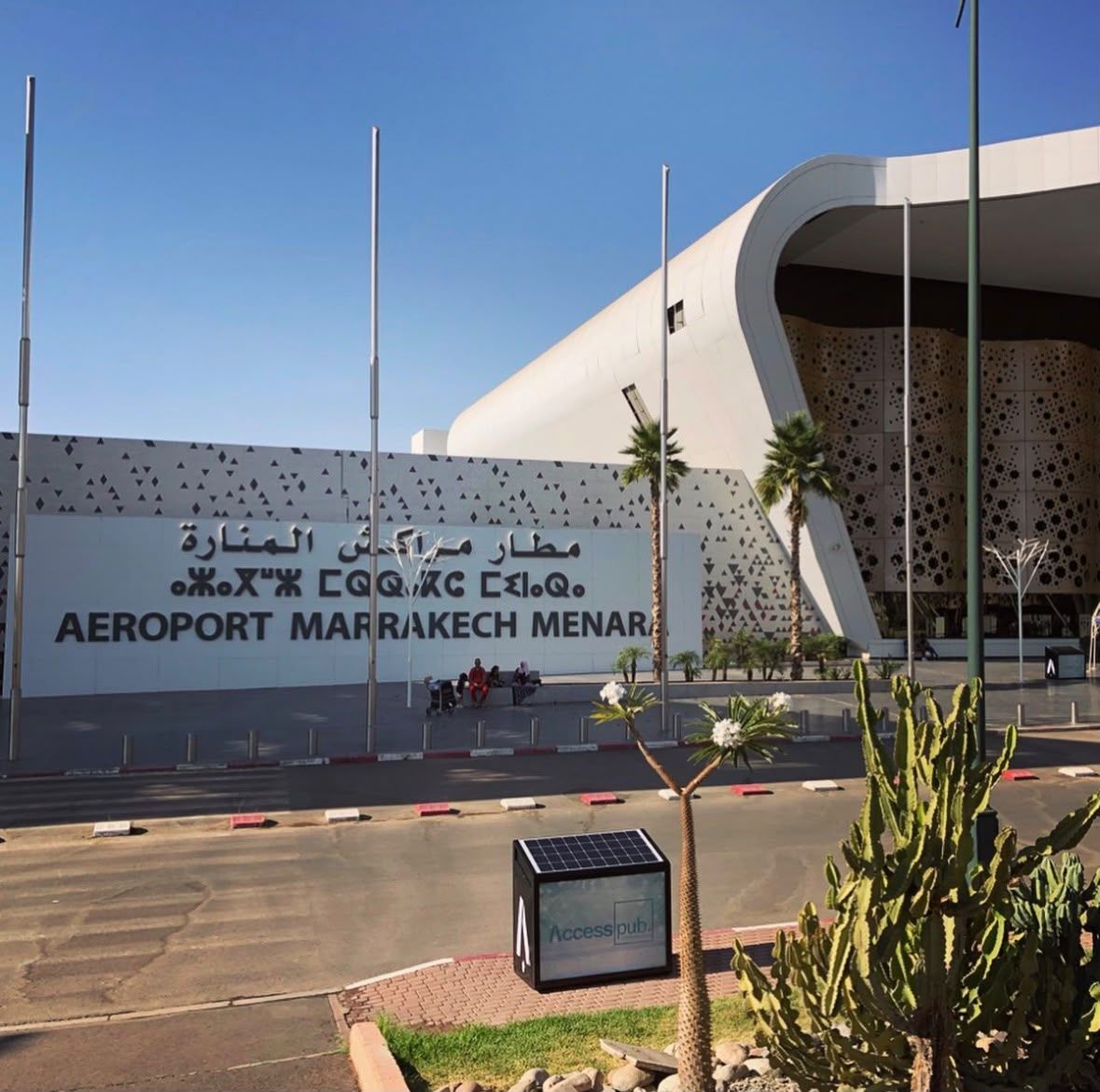Marrakech Menara Airport facade with Aeroport Marrakech Menara sign and palm trees