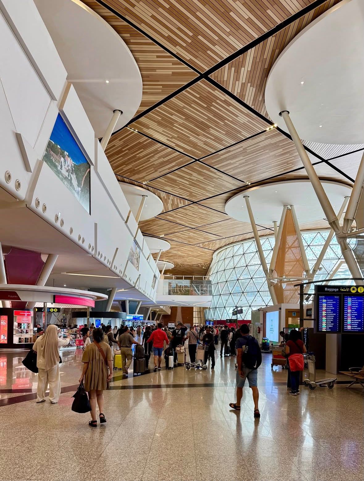 Wide terminal walkway inside Marrakech Menara Airport with a geometric ceiling